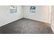 Bright, empty bedroom with soft gray carpet, white walls and two windows overlooking the lawn at 6003 W Harwood Ave, Orlando, FL 32835