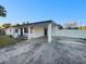 Charming single-story home featuring a covered porch with gray driveway and white privacy fence at 6003 W Harwood Ave, Orlando, FL 32835