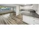 Bright, open kitchen featuring white cabinets, gray countertops and modern wood floors at 6003 W Harwood Ave, Orlando, FL 32835