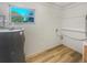 Bright utility room with wood-look flooring, white walls, and a window with a view at 6003 W Harwood Ave, Orlando, FL 32835