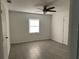 Well-lit bedroom showcasing neutral walls, contemporary ceiling fan, and stylish flooring at 613 20Th St, Orlando, FL 32805