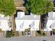 Aerial view of townhouses with white roofs, driveways, and well-maintained lawns and landscaping at 6936 Della Dr # 33, Orlando, FL 32819