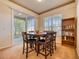 Cozy dining area features a wooden table, four chairs, sliding glass door, and decorative bookcase at 6936 Della Dr # 33, Orlando, FL 32819