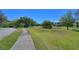 Well-maintained landscaping around the community includes sidewalk, grass, pond and mature trees at 6936 Della Dr # 33, Orlando, FL 32819