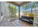 Enclosed patio with tile flooring, features a black futon and view of the gravel and planted garden at 6936 Della Dr # 33, Orlando, FL 32819