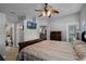Spacious main bedroom with bathroom access featuring dark wood furniture, ceiling fan and a wall-mounted television at 696 Seabrook Ct # 101, Altamonte Springs, FL 32714