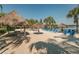 Sandy beach area offers sun loungers, tiki umbrellas, and lake views for a resort-like community experience at 806 Lucaya Loop, Davenport, FL 33897