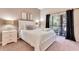 Serene bedroom with a plush white bed, balcony access, and elegant decor at 806 Lucaya Loop, Davenport, FL 33897