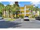 Charming yellow condominium complex with white railings, surrounded by lush landscaping and convenient parking at 806 Lucaya Loop, Davenport, FL 33897