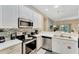 Well-appointed kitchen featuring stainless steel appliances, white cabinetry, and a tiled backsplash at 806 Lucaya Loop, Davenport, FL 33897