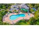 Aerial view of a community pool surrounded by lounge chairs, lush landscaping and palm trees at 806 Lucaya Loop, Davenport, FL 33897