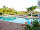 Community pool with palm trees, lounge chairs, and lake views at 806 Lucaya Loop, Davenport, FL 33897