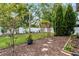 Backyard features a stepping stone pathway and a wooden arched trellis in a mulch landscape design at 9054 Sandwood Way, Orlando, FL 32832