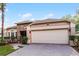 Inviting home with a stone accent wall, neutral paint, a large garage, and a neatly paved driveway at 9054 Sandwood Way, Orlando, FL 32832