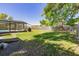Large backyard featuring a screen enclosed pool, green grass, and a wood fence at 9501 Holbrook Dr, Orlando, FL 32817