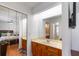 View into this bathroom with double mirrored closet, vanity, and view into the primary bedroom at 9501 Holbrook Dr, Orlando, FL 32817
