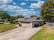 Single-story home with an attached garage and long driveway, featuring stone accents, landscaping, and a well-maintained lawn at 9501 Holbrook Dr, Orlando, FL 32817