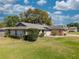 Charming single-story home with a well-manicured lawn, shrubbery, and stone accents under a bright sky at 9501 Holbrook Dr, Orlando, FL 32817