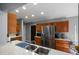 Modern kitchen featuring stainless steel refrigerator, wood cabinets, and hard surface countertops at 9501 Holbrook Dr, Orlando, FL 32817
