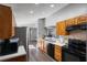 Open kitchen with wood cabinets, stainless steel refrigerator, and black appliances at 9501 Holbrook Dr, Orlando, FL 32817
