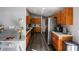 Long bright kitchen features wood cabinets, stainless steel appliances, hard surface counters, and wood flooring at 9501 Holbrook Dr, Orlando, FL 32817