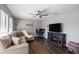 Bright living room featuring wood flooring, ceiling fan, tv, and comfortable seating at 9501 Holbrook Dr, Orlando, FL 32817