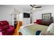 This primary bedroom features a ceiling fan, tv, ensuite bathroom, and comfortable seating at 9501 Holbrook Dr, Orlando, FL 32817