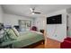 Comfortable main bedroom featuring wood floors, ceiling fan, tv, and pool view at 9501 Holbrook Dr, Orlando, FL 32817