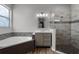 Modern bathroom with vanity, soaking tub with tile surround, and glass enclosed shower at 9899 Leland Dr, Orlando, FL 32827