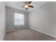 A cozy bedroom featuring neutral walls, carpet flooring, a ceiling fan, and bright natural light at 9899 Leland Dr, Orlando, FL 32827