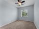 A serene bedroom featuring light blue walls, carpet flooring, a ceiling fan, and plenty of natural light at 9899 Leland Dr, Orlando, FL 32827