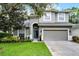 Charming two-story home with well-manicured lawn and attached two-car garage at 9899 Leland Dr, Orlando, FL 32827