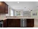 Kitchen featuring stainless steel dishwasher, dark cabinets, and light countertops overlooking the lanai at 9899 Leland Dr, Orlando, FL 32827