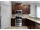 View of kitchen with stainless steel appliances, dark cabinets, and sink at 9899 Leland Dr, Orlando, FL 32827