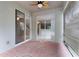 Covered patio area featuring brick flooring and sliding glass doors to the home's interior at 9899 Leland Dr, Orlando, FL 32827