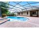 Beautiful pool with brick patio area, steps into the water, and screened enclosure at 9899 Leland Dr, Orlando, FL 32827