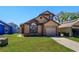 Charming tan two-story home with a well-manicured lawn and attached one car garage on a sunny day at 10020 Creekwater Blvd, Orlando, FL 32825