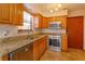 Well-lit kitchen features granite counters, stainless steel appliances, and wooden cabinets at 10020 Creekwater Blvd, Orlando, FL 32825