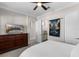 Relaxing bedroom with a large dresser, TV, ceiling fan, and neutral decor at 10655 Village Lake Rd, Windermere, FL 34786
