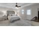 Elegant bedroom with a comfortable bed, tray ceiling, two bedside tables with lamps, and soft carpeting at 10655 Village Lake Rd, Windermere, FL 34786