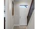 Bright entryway with tile floors, white door, and wooden staircase creating a welcoming ambiance at 10655 Village Lake Rd, Windermere, FL 34786