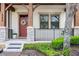 Close-up of a townhouse front porch with stone pillars and a welcoming red door at 10655 Village Lake Rd, Windermere, FL 34786