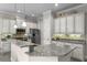 Bright kitchen features white cabinetry, stainless steel appliances, and granite countertops at 10655 Village Lake Rd, Windermere, FL 34786