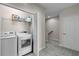 Convenient laundry room with a washer and dryer, storage shelves, and easy access to the upper level at 10655 Village Lake Rd, Windermere, FL 34786