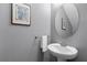 Powder room with pedestal sink and a round mirror at 10655 Village Lake Rd, Windermere, FL 34786