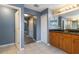 Bathroom with granite counters, wooden cabinets, tile floors and a view into the hallway with plank flooring at 110 Wekiva Pointe Cir, Apopka, FL 32712