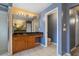 Well-lit bathroom vanity with wood cabinets, granite counters, and a mirror featuring multiple lights above at 110 Wekiva Pointe Cir, Apopka, FL 32712