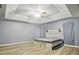 Bedroom with light gray walls, wood floors, a tray ceiling, and a large headboard with sconces at 110 Wekiva Pointe Cir, Apopka, FL 32712