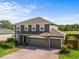 Two-story home with a three-car garage, neutral paint, brick driveway, and well-maintained landscaping at 110 Wekiva Pointe Cir, Apopka, FL 32712