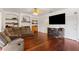 Relax in this living room with hardwood floors, built-in shelves, and an entertainment center with a fireplace at 110 Wekiva Pointe Cir, Apopka, FL 32712